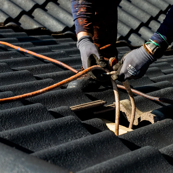 Tiilikaton kuntotarkastaja kiinnittämässä turvaköyttä.